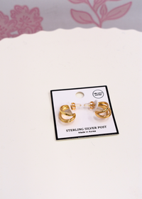 Layered gold hoop earrings featuring three connected hoops