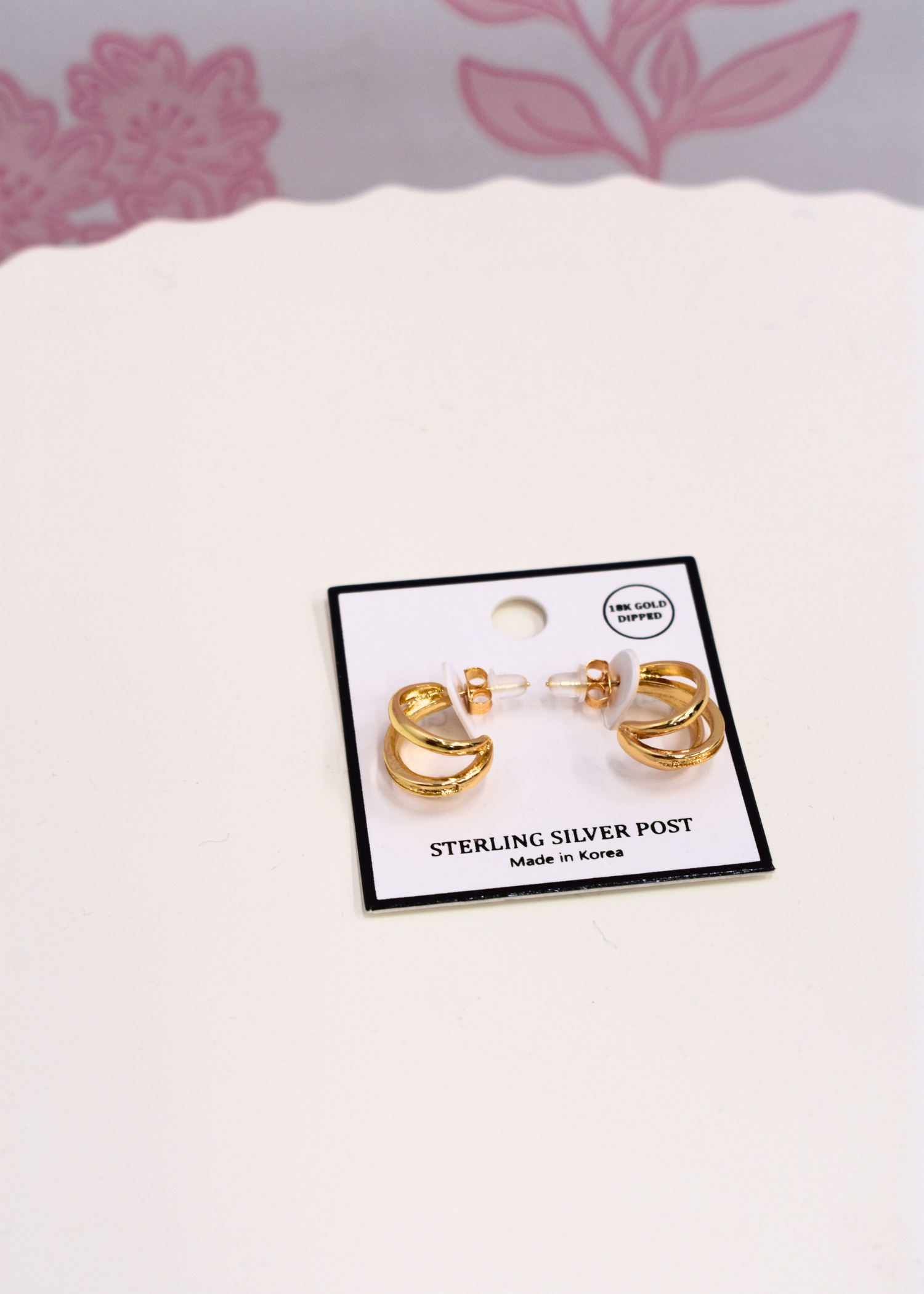 Layered gold hoop earrings featuring three connected hoops