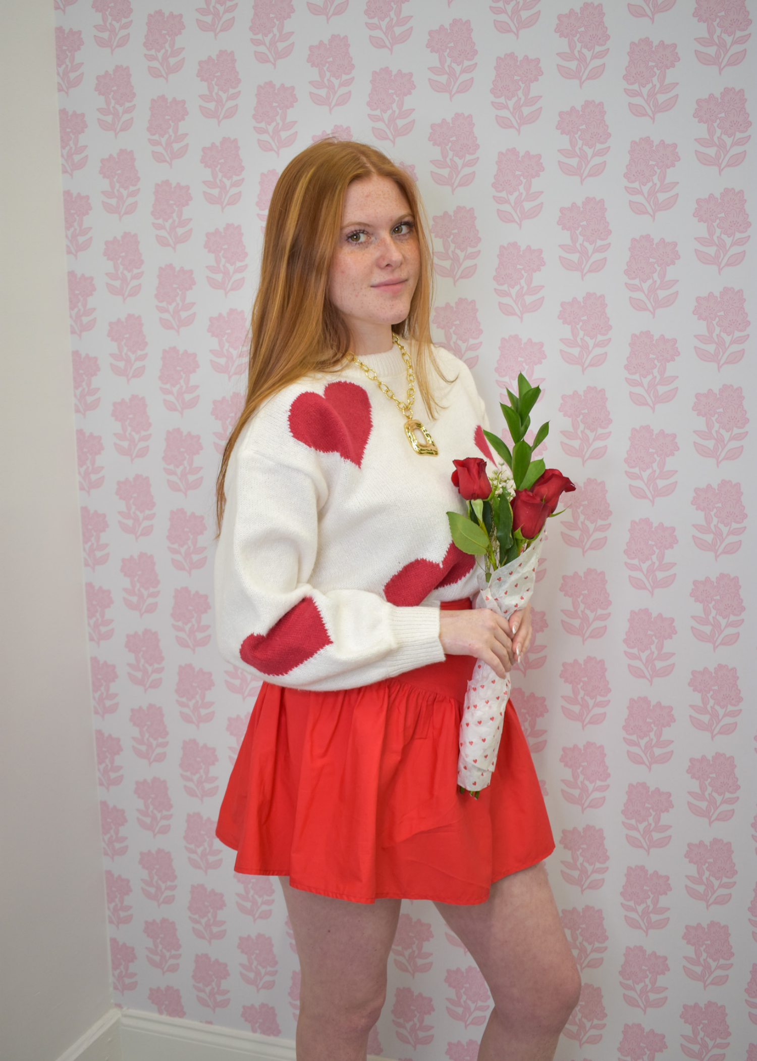 Valentine-ready cream sweater with bold red heart accents