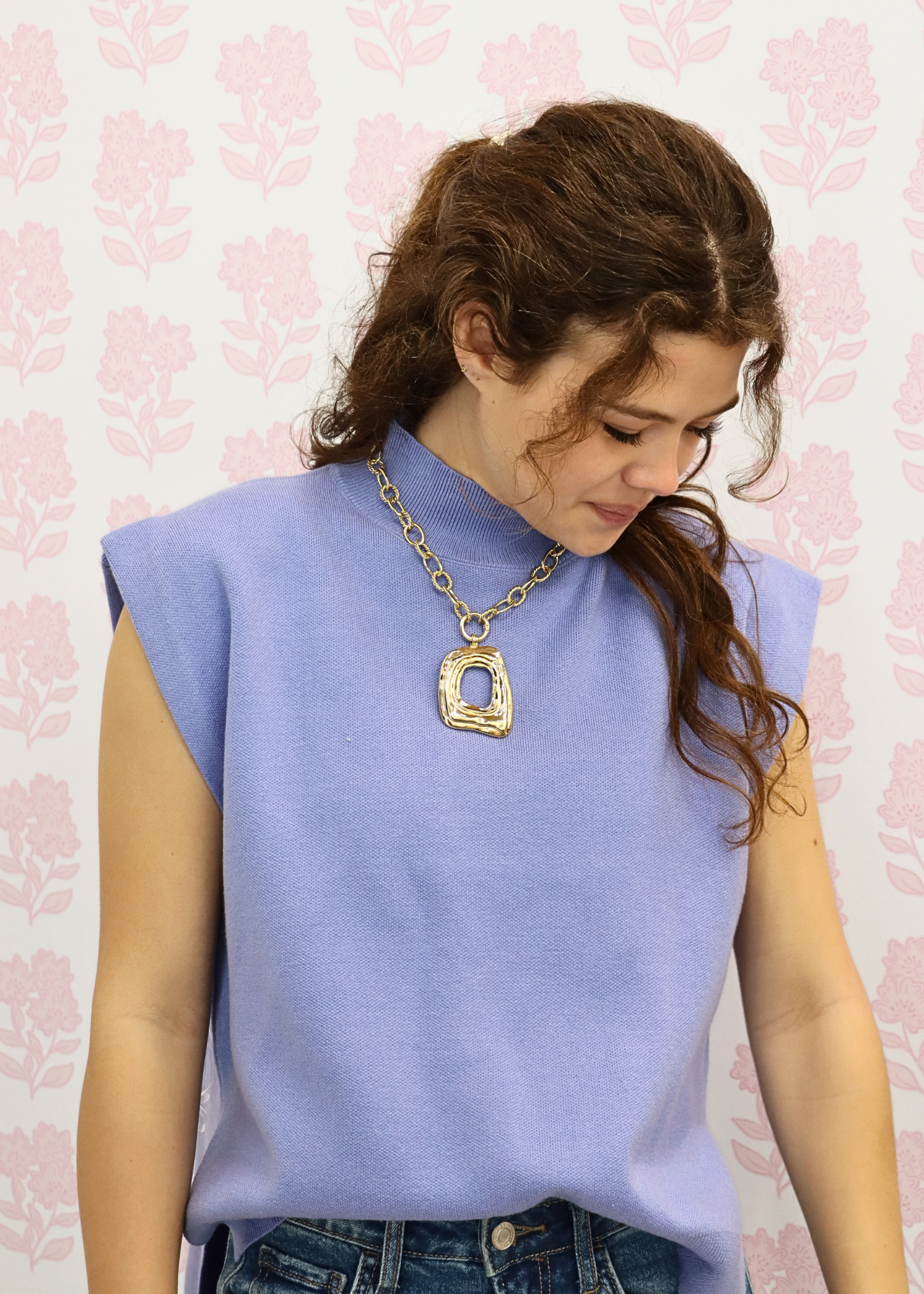 Baby blue sleeveless mock neck knit top styled with denim outfit and gold statement necklace