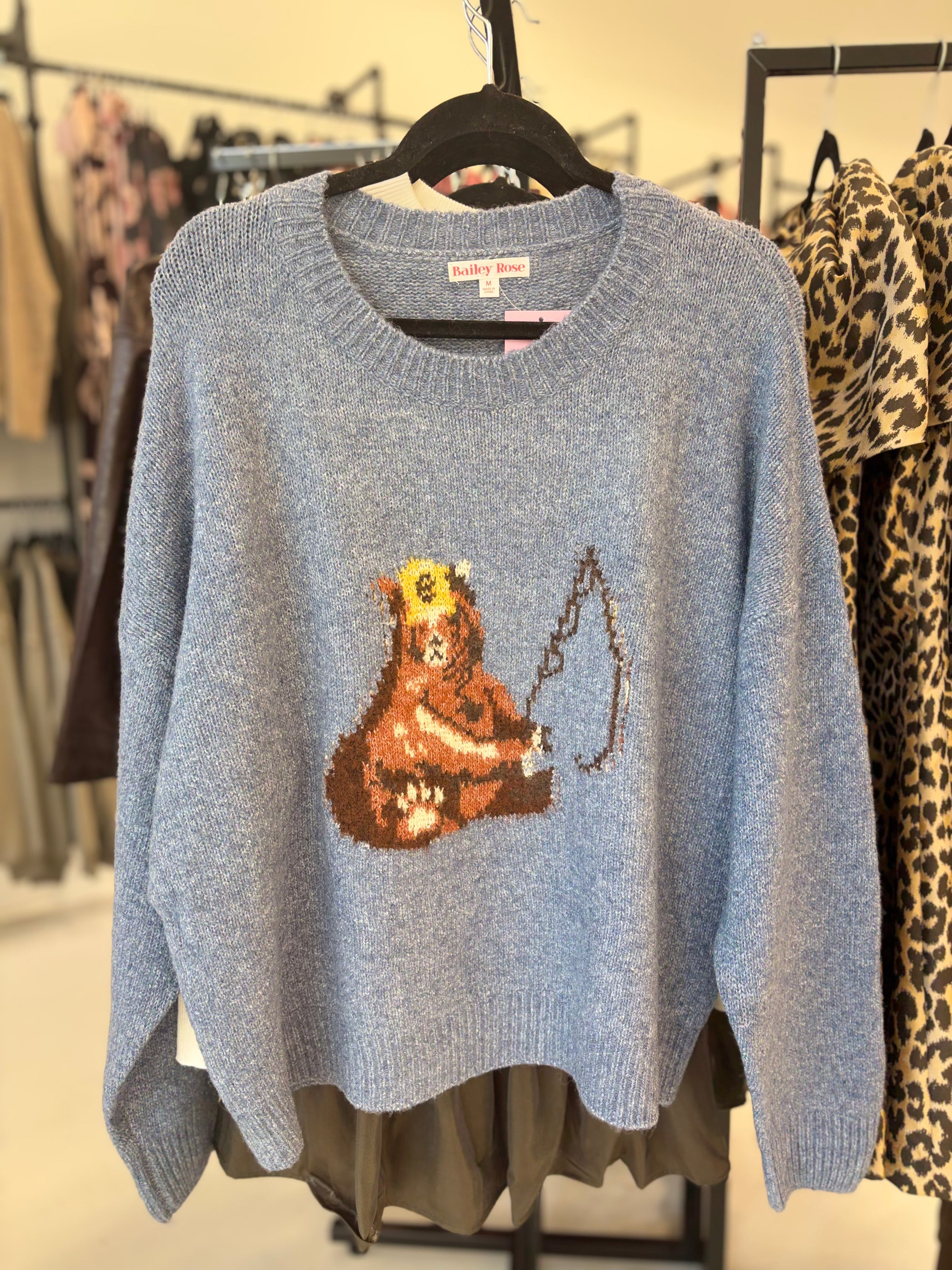 Bear fishing on knit sweater on rack of trendy boutique