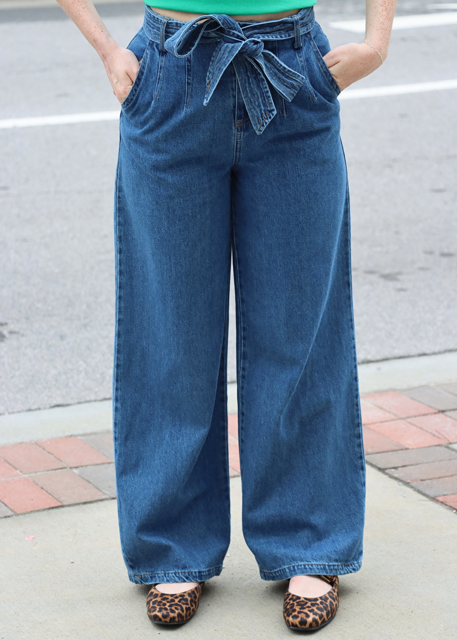 Close up of belt detail on high rise dark wash denim pants
