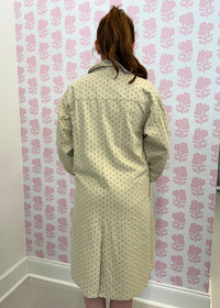 Back view of beige polka dot denim trench coat with belt