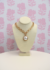 Statement gold necklace featuring a domed pearl pendant