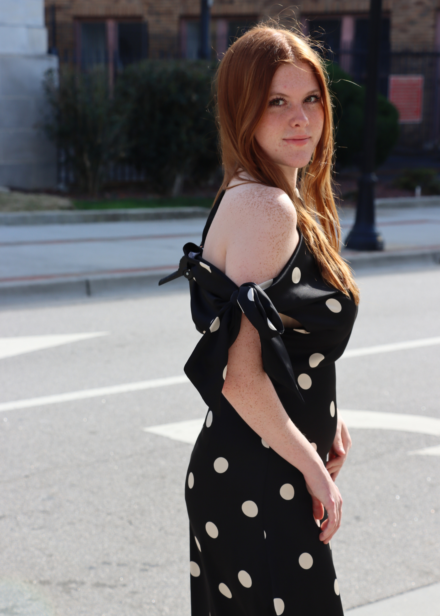Side view of satin polka dot bias cut dress with asymmetrical strap