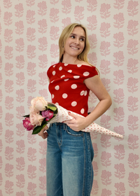 Stylish red and white polka dot sweater with unique off-center neckline