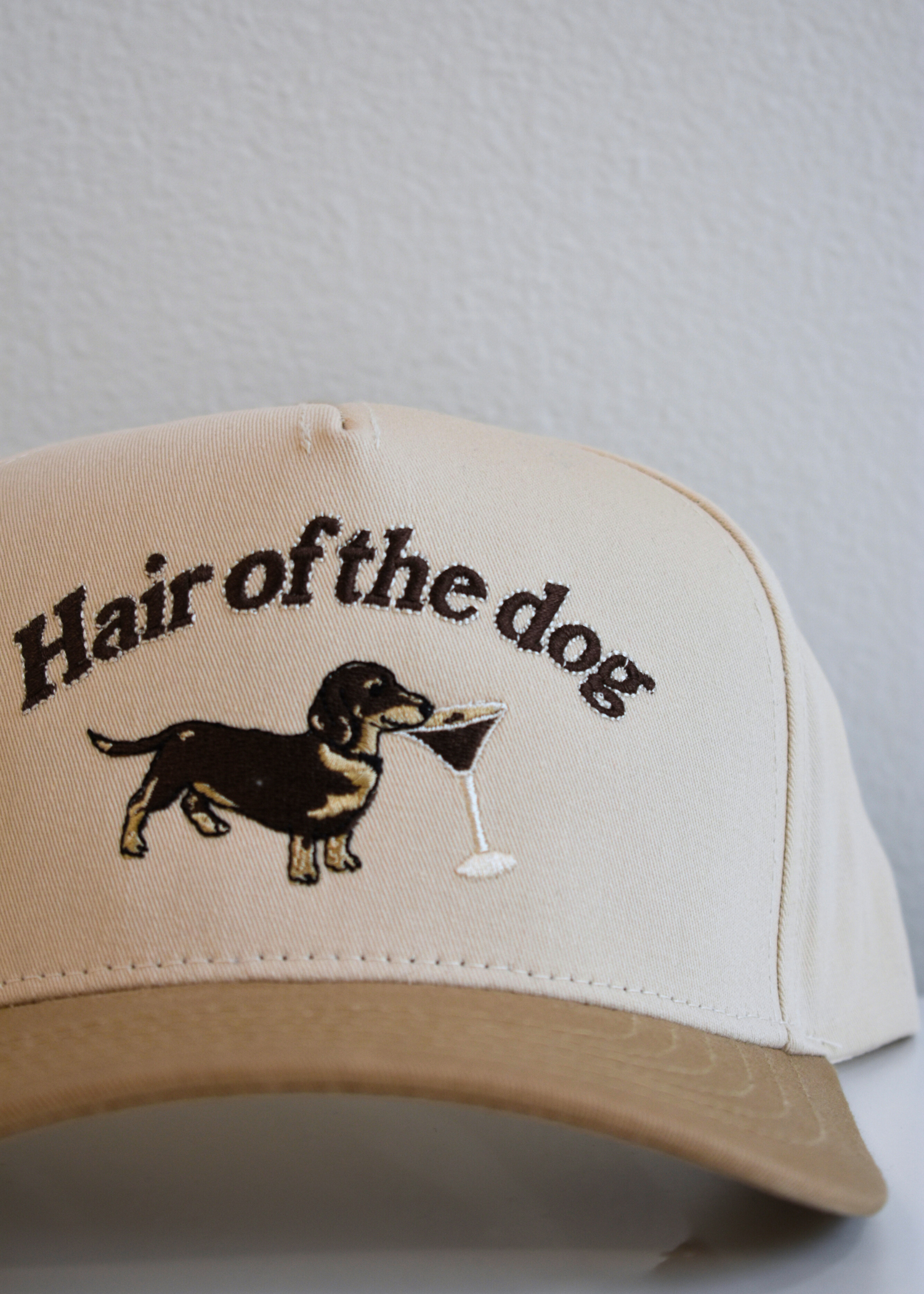Close up of dachshund and espresso martini embroidery on tan and natural vintage snapback hat