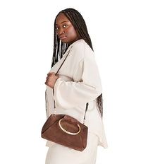 Styled view of suede clutch with zipper pocket and gold hardware