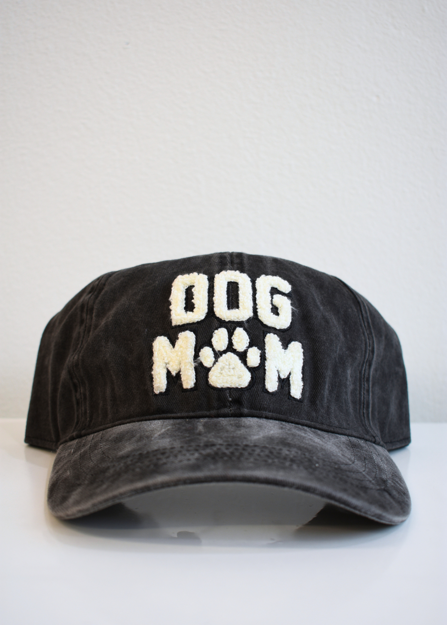 Close up of Dog Mom embroidery on washed black dad hat