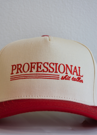 Close up of Professional Shit Talker embroidery on red and natural snapback hat