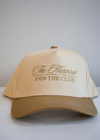 Front view of The Happiest cursive tan and natural vintage trucker hat