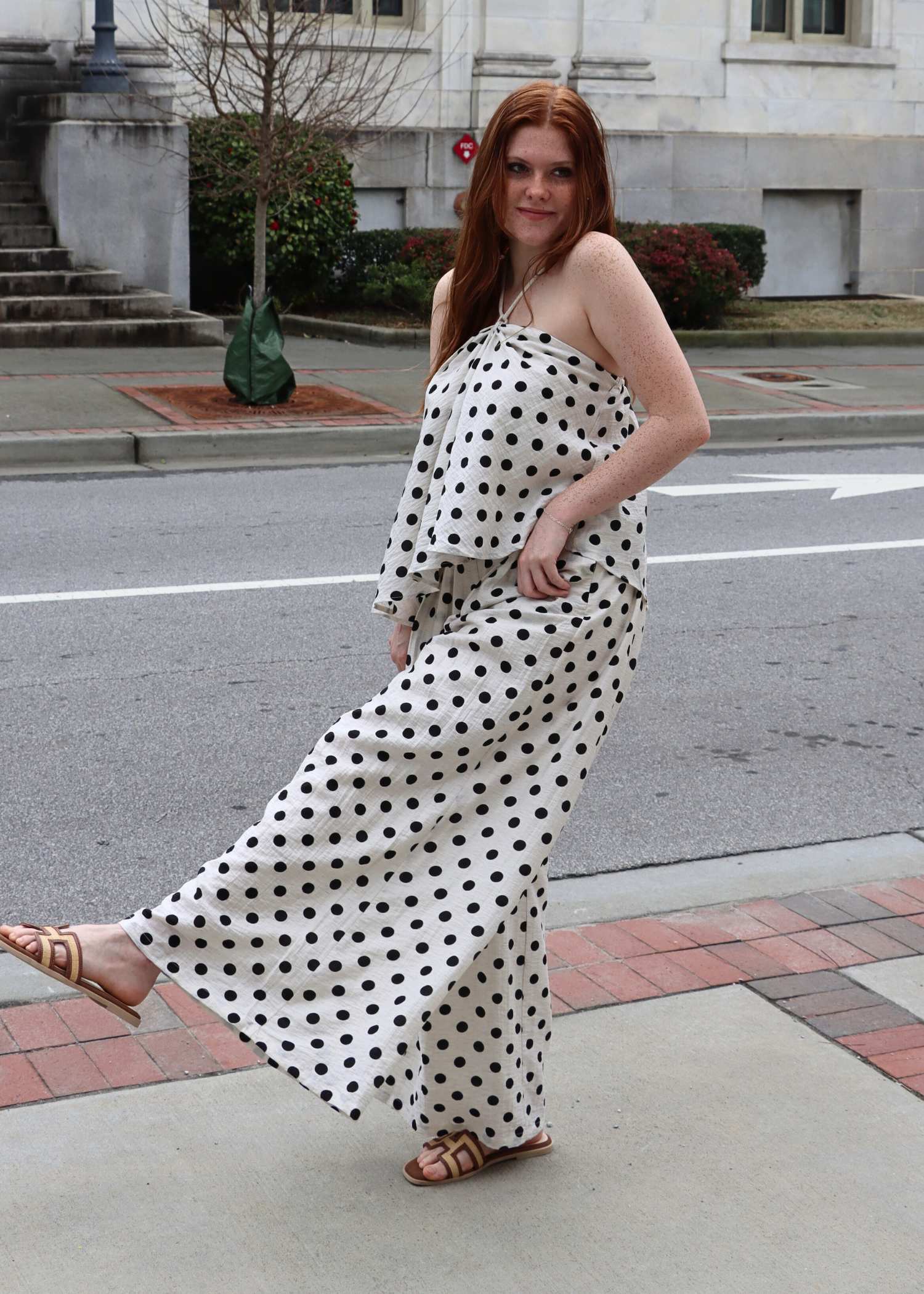 Side view of high rise polka dot linen pants with relaxed wide leg silhouette
