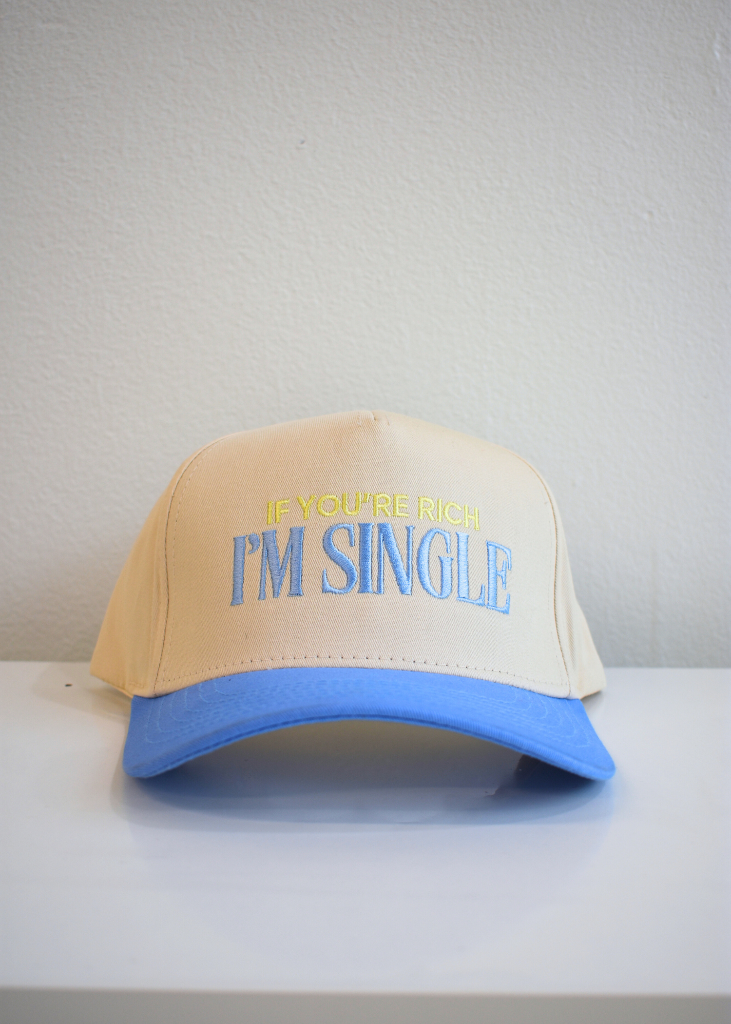 Front view of I'm Single periwinkle and natural vintage trucker hat with embroidered slogan
