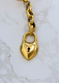 Locket style gold bag charm with chain detail
