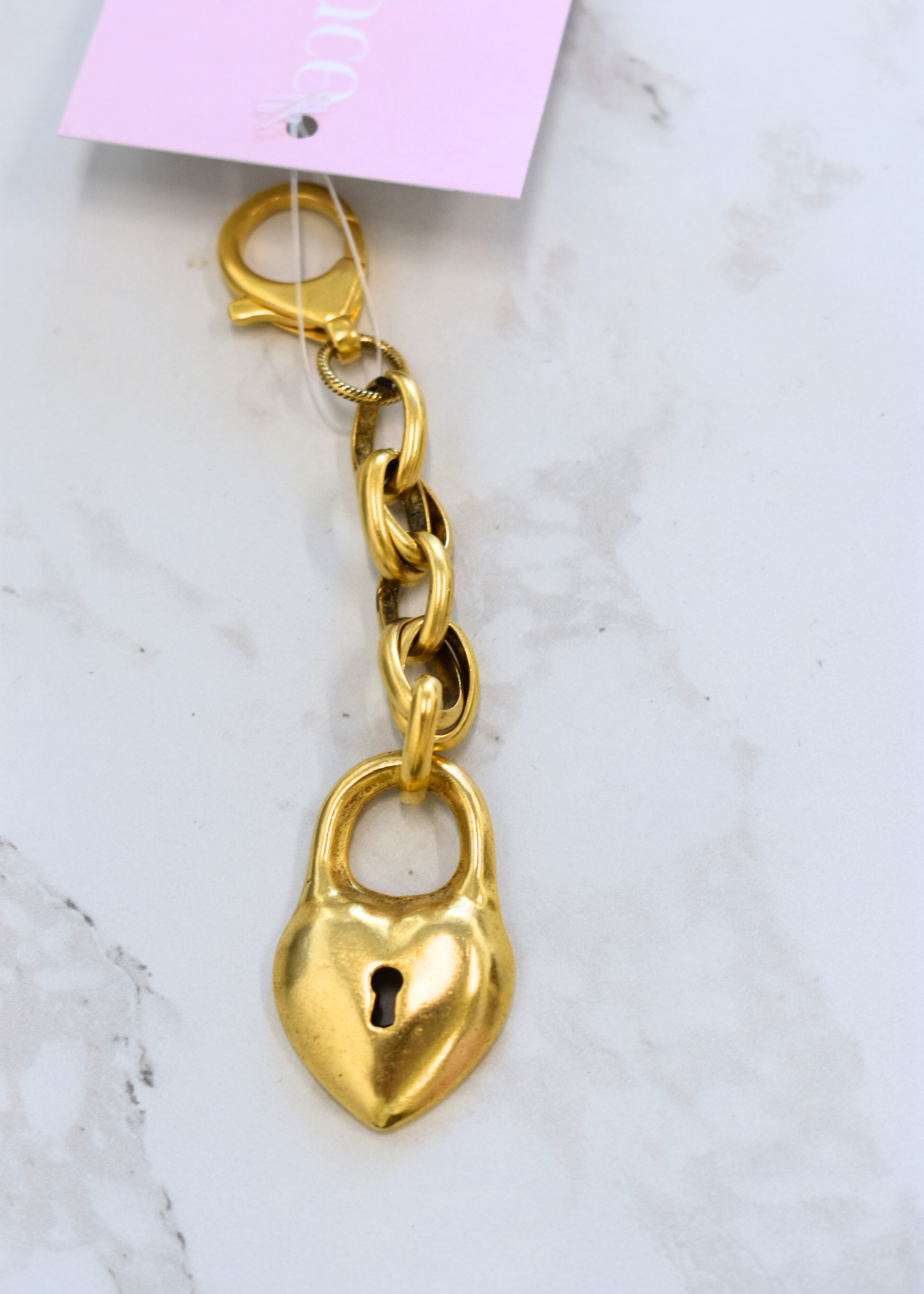 Gold locket bag charm with polished finish