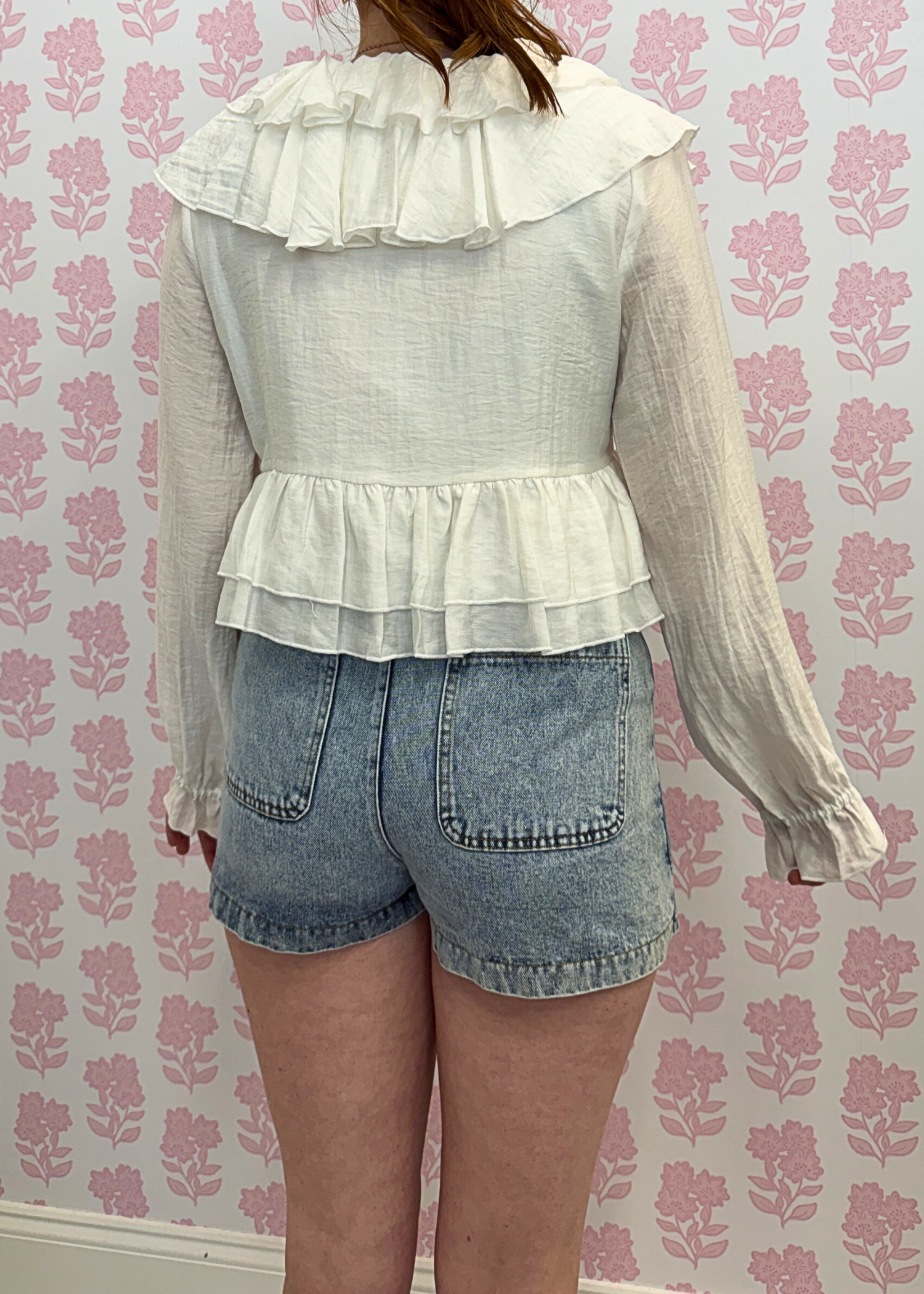 back view of Light wash denim mini skort styled with casual outfit