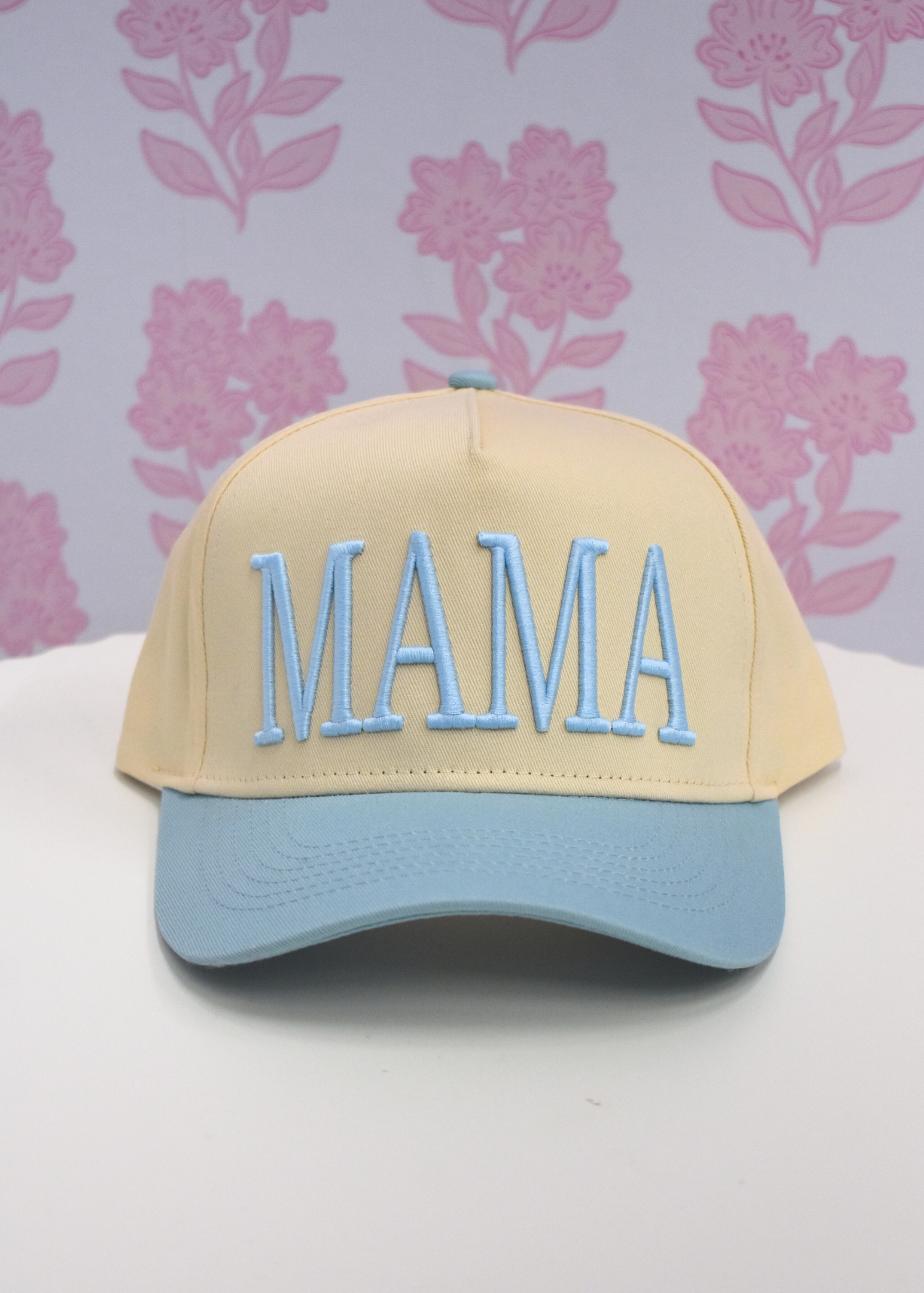 Front view of baby blue MAMA trucker hat with breathable mesh panel