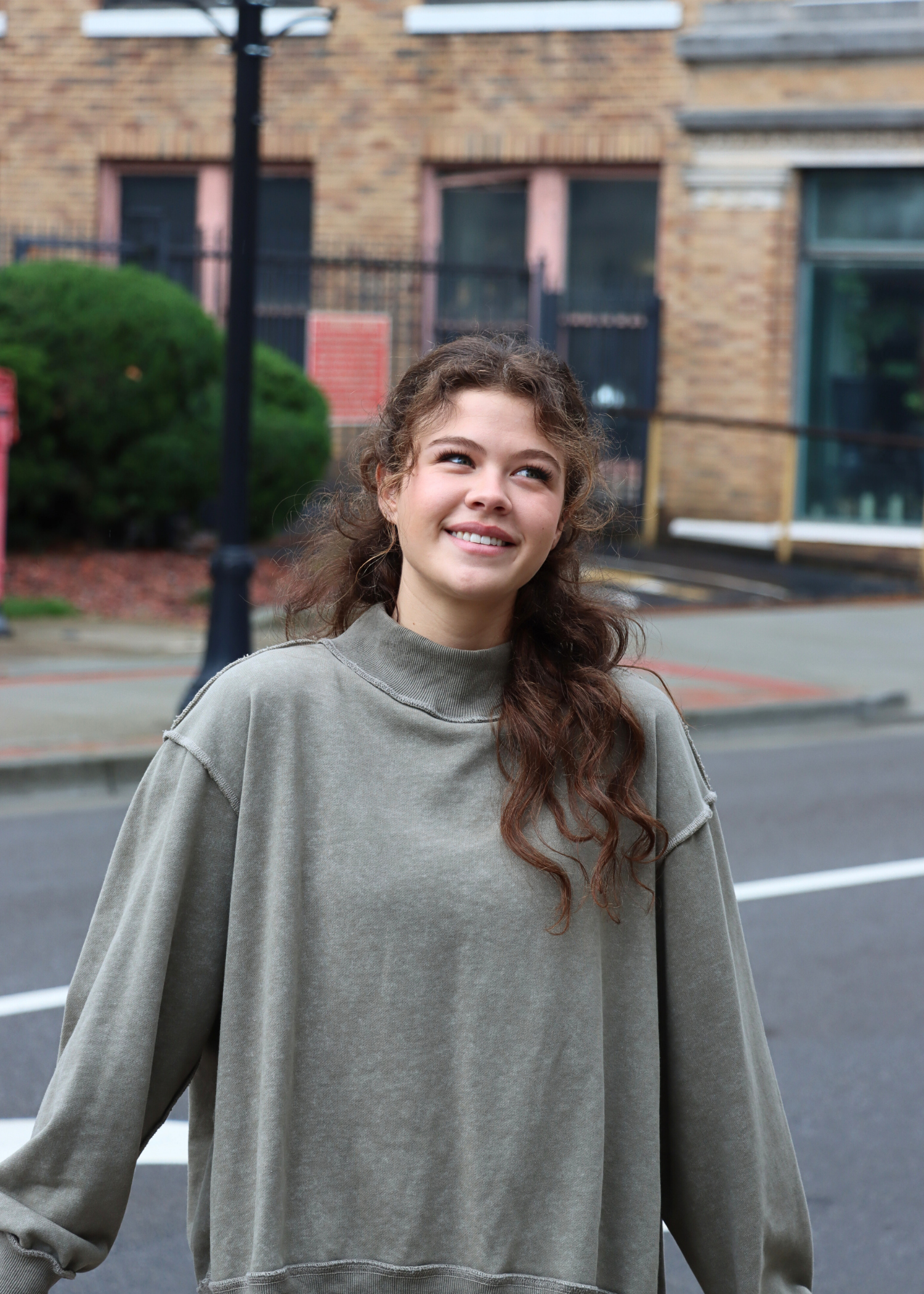 Olive mock neck sweatshirt styled with casual denim outfit