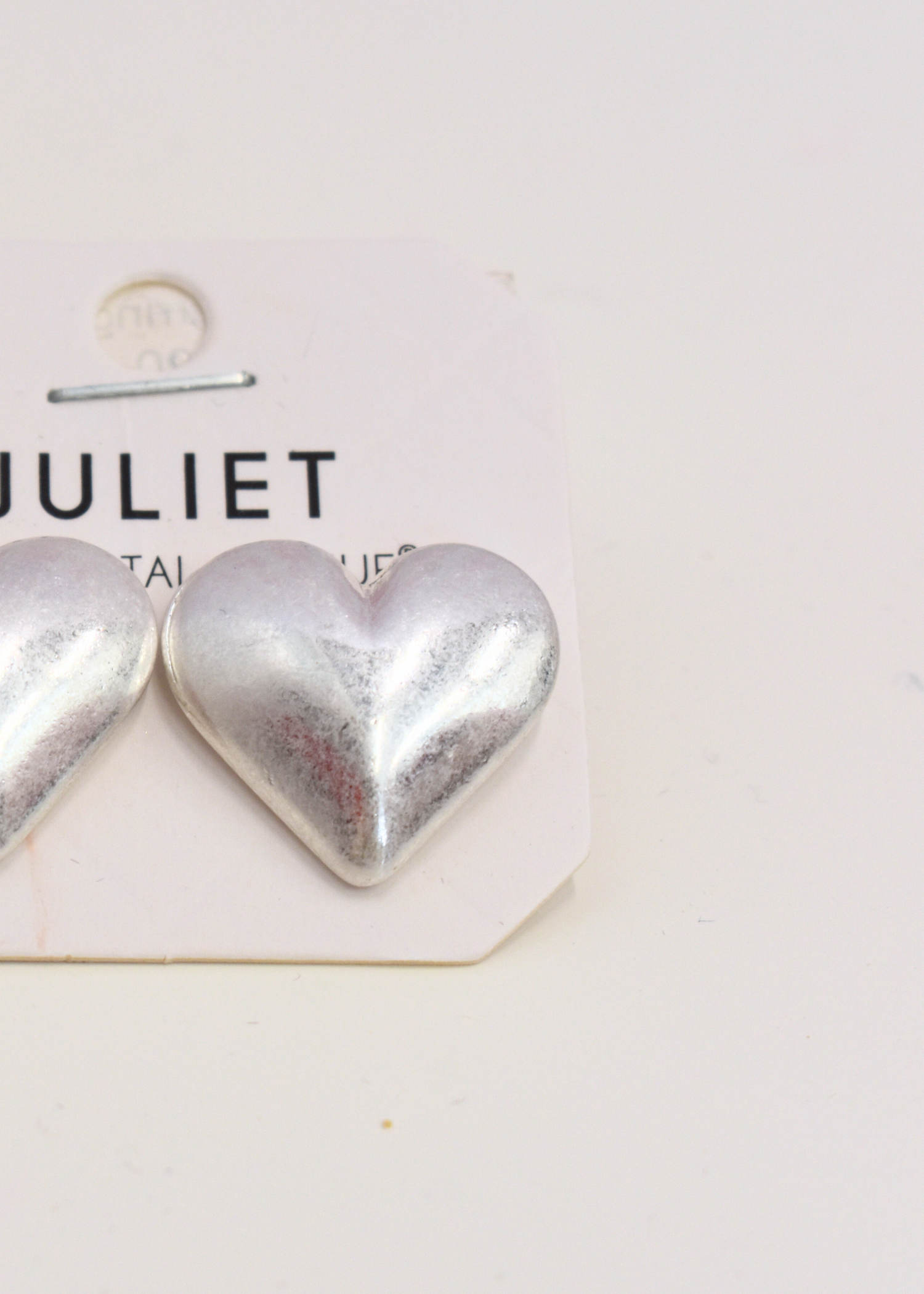 Silver heart earrings featuring rounded puffy design