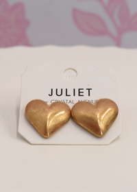 Worn gold puffy heart earrings with vintage inspired finish