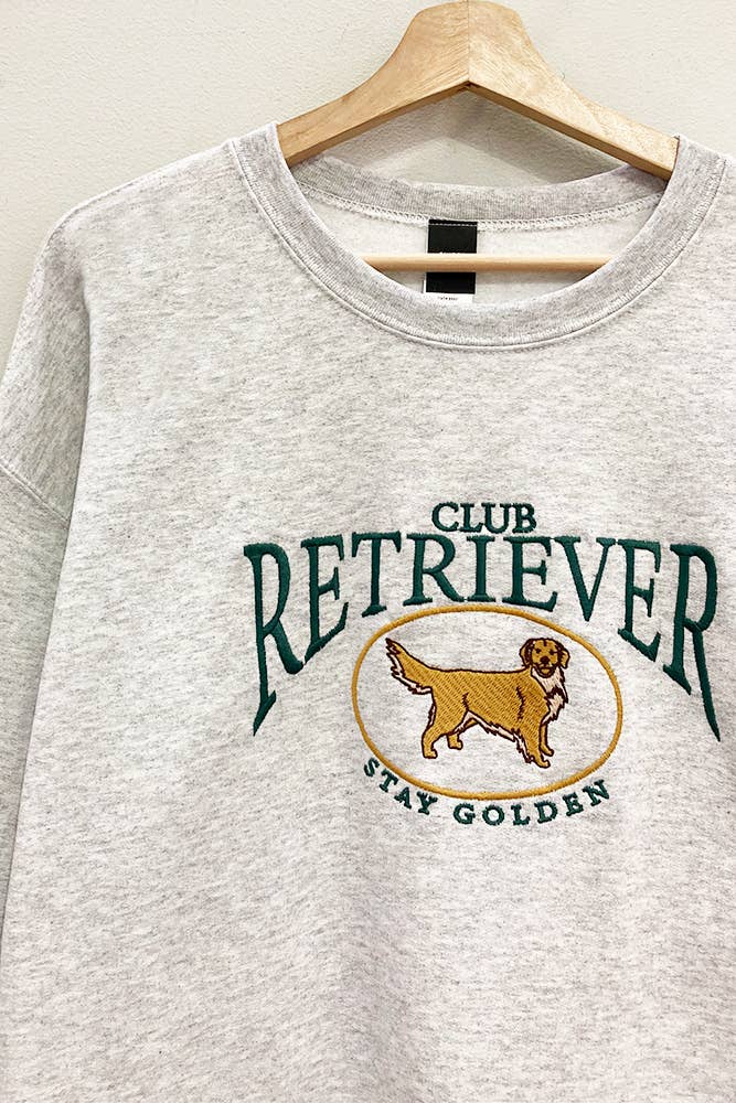 Embroidered retriever club sweatshirt hanging on hanger