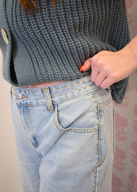 Close up of silver stud detailing on flare jeans