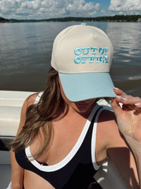 Side view of unisex Out of Office trucker hat on a boat