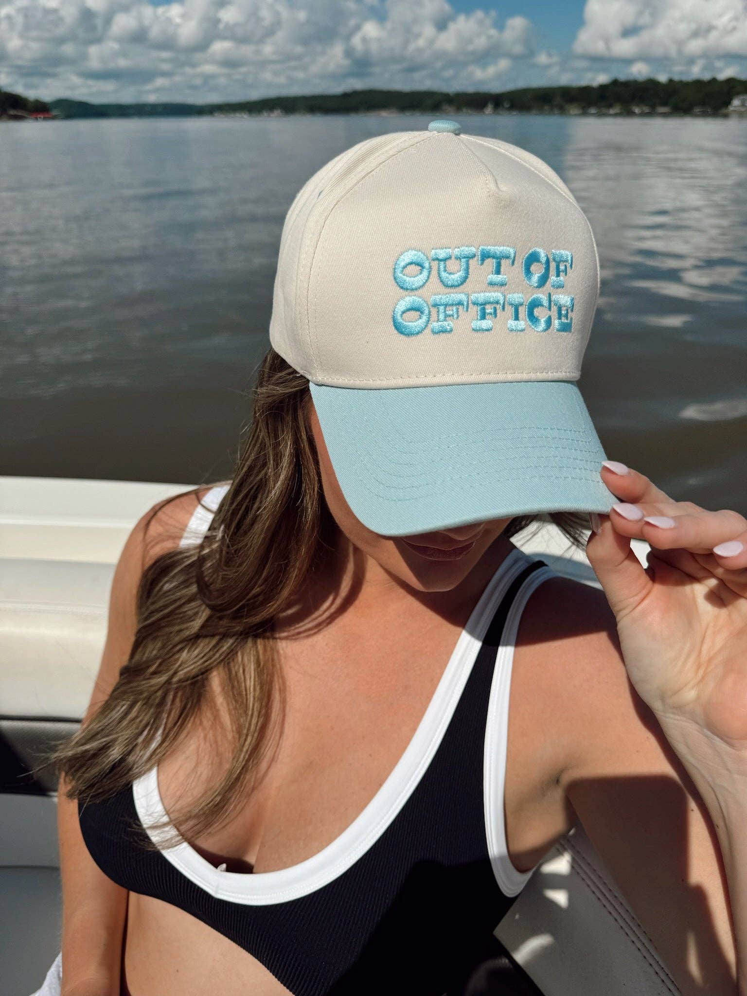 Side view of unisex Out of Office trucker hat on a boat