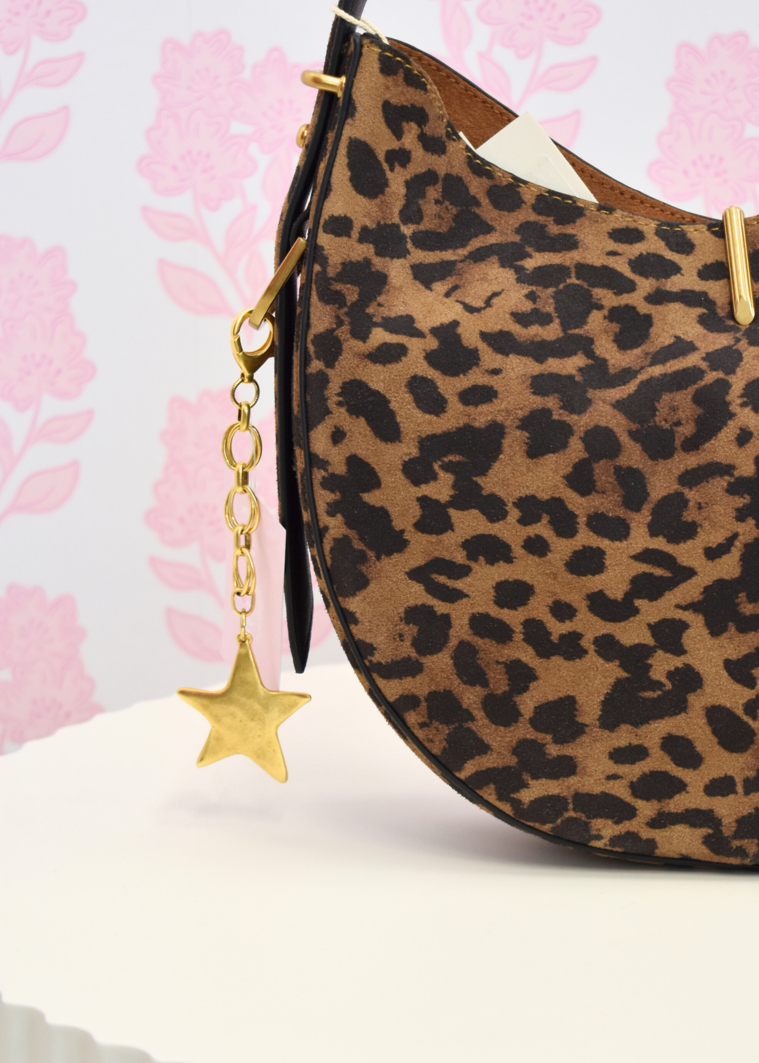 Gold star bag charm styled on handbag