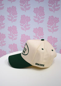 Close up detail of God is Good graphic on green vintage trucker hat