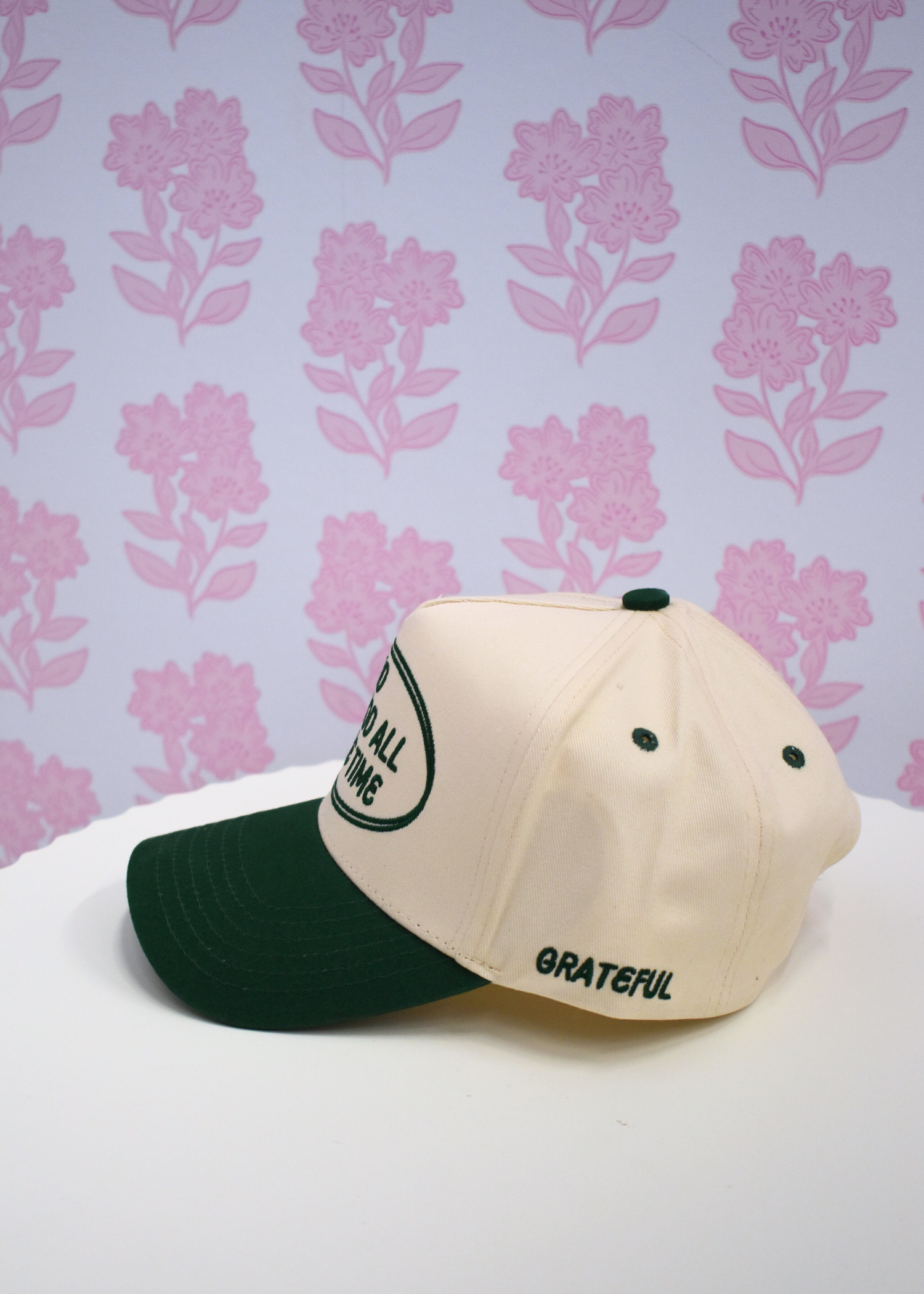 Close up detail of God is Good graphic on green vintage trucker hat